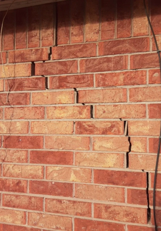 brick wall with a stair-step pattern crack